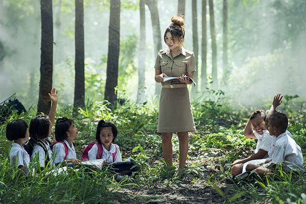 Teacher with a book teaching reading to English Language Learners on Language Avenue